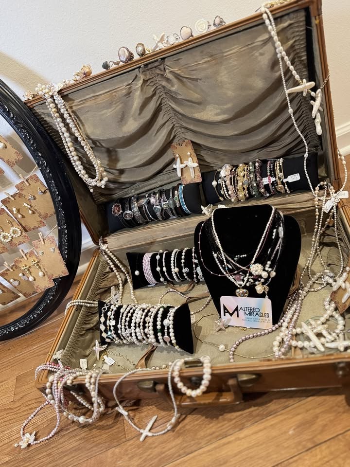 Altered Miracles pearl necklaces, bracelets and rings displayed in an open vintage suitcase