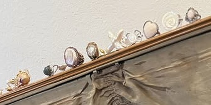 Pearl and natural stone rings lined up along the suitcase lid